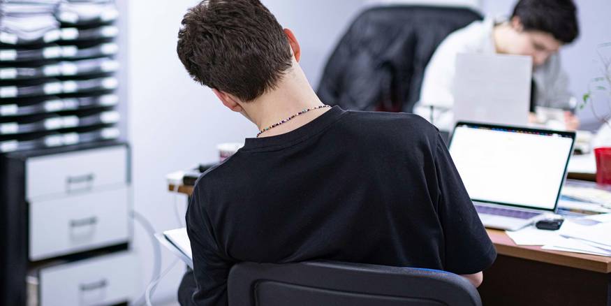 A person confidently using a laptop in a modern workspace, representing secure dashboard access and account management
